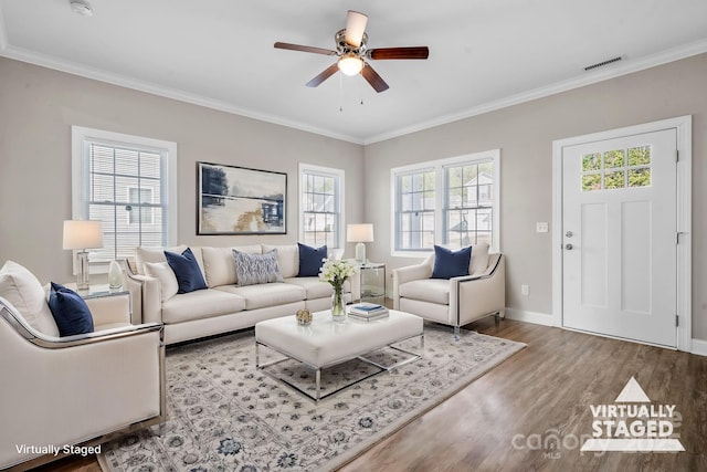 living room featuring visible vents, wood finished floors, a ceiling fan, and crown molding