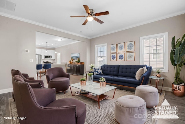 living area with baseboards, wood finished floors, and crown molding