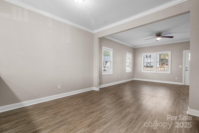 unfurnished room with ornamental molding, ceiling fan, baseboards, and dark wood-style flooring