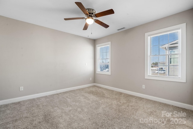 spare room featuring visible vents, baseboards, a ceiling fan, and carpet flooring