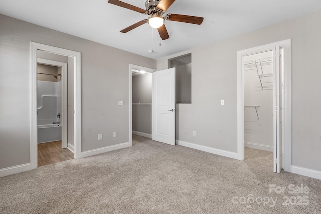 unfurnished bedroom with a closet, a walk in closet, and carpet floors