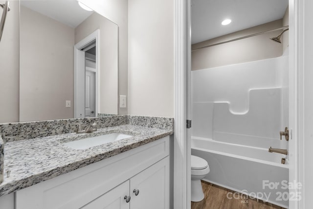 full bathroom with vanity, toilet, wood finished floors, and tub / shower combination