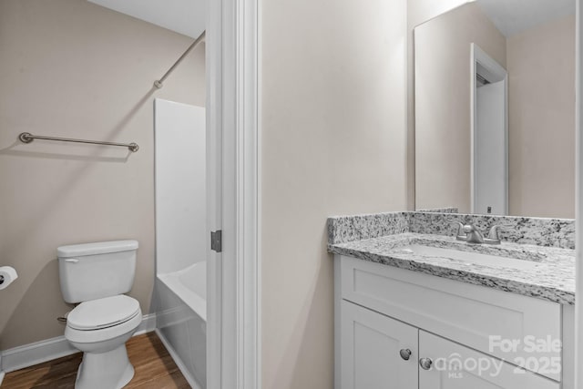 full bath featuring baseboards, toilet, bathing tub / shower combination, wood finished floors, and vanity