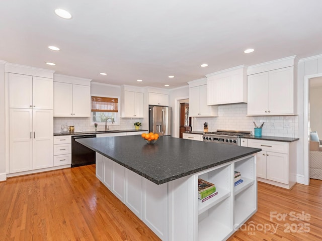 kitchen with dishwasher, white cabinets, stainless steel fridge, and a sink