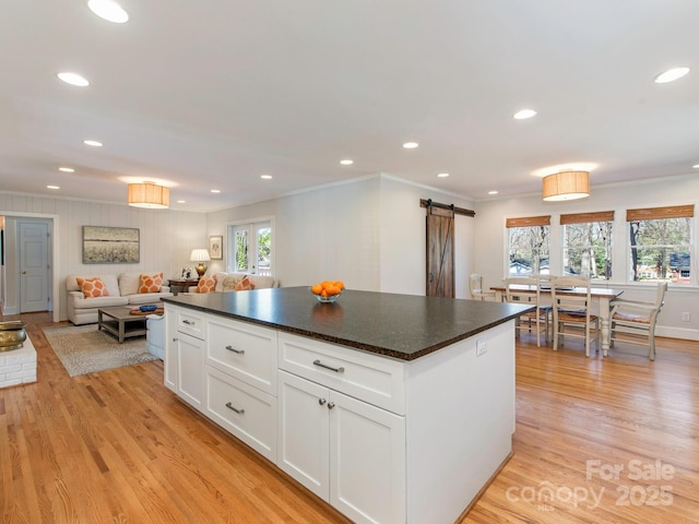 kitchen featuring a barn door, dark countertops, and a healthy amount of sunlight