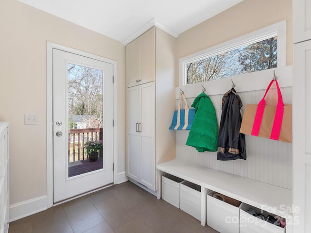 mudroom with baseboards and dark tile patterned floors