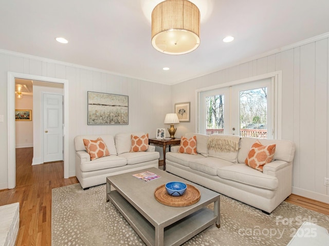 living room with wood finished floors, baseboards, recessed lighting, ornamental molding, and french doors