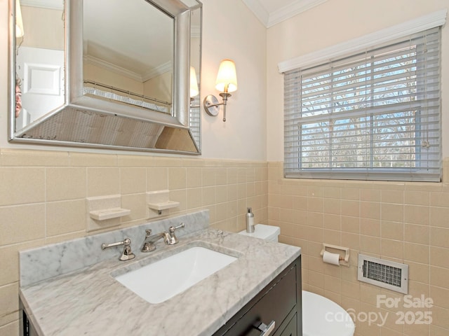 bathroom featuring vanity, visible vents, crown molding, toilet, and tile walls