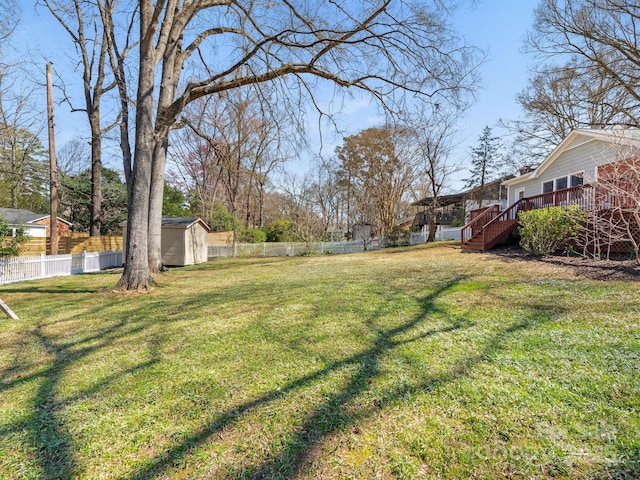 view of yard featuring a fenced backyard, an outdoor structure, a storage shed, and a deck