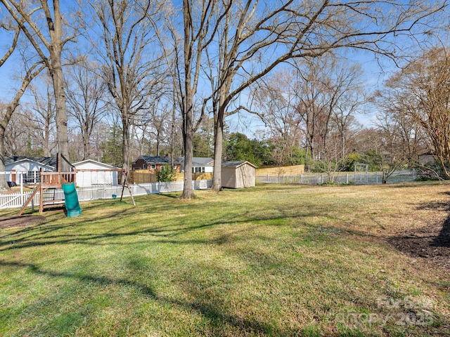 view of yard with a fenced backyard, a storage shed, and an outdoor structure