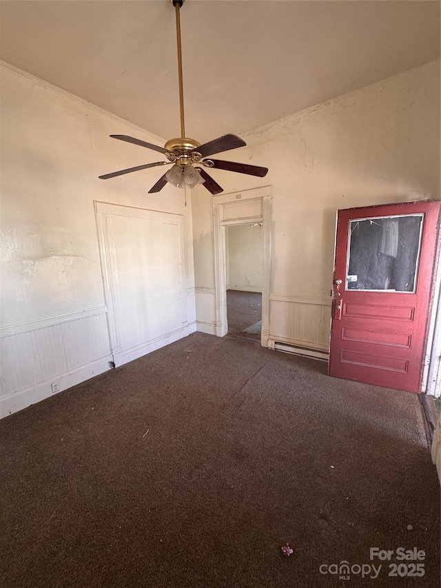 interior space with a ceiling fan, carpet, and wainscoting