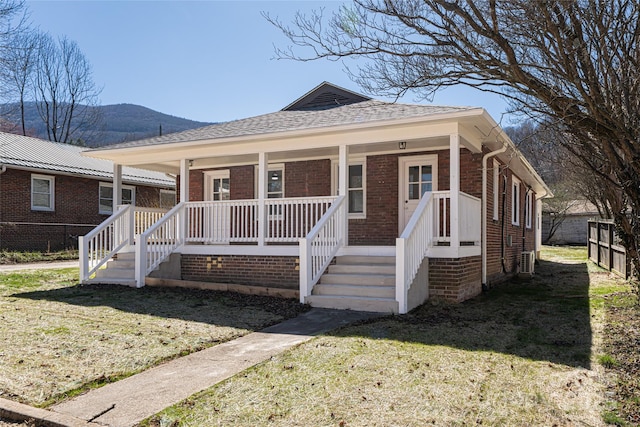 bungalow-style house featuring a porch, brick siding, and a front yard