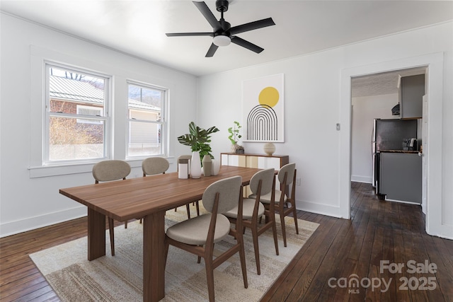 dining space featuring dark wood finished floors, ceiling fan, and baseboards