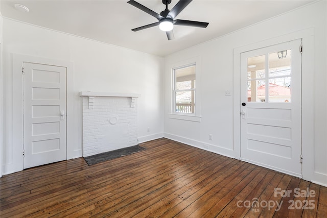 unfurnished living room featuring a brick fireplace, dark wood-style floors, baseboards, and ceiling fan