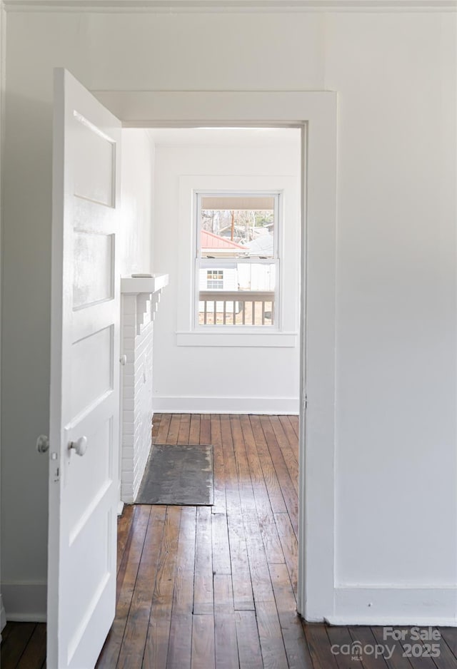 hall with dark wood finished floors and baseboards