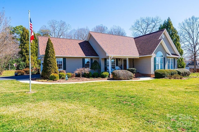 ranch-style house with a front yard and roof with shingles