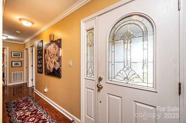 foyer entrance with dark wood-type flooring, baseboards, visible vents, and ornamental molding