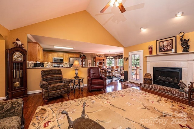 living room with baseboards, high vaulted ceiling, a fireplace with raised hearth, and dark wood finished floors