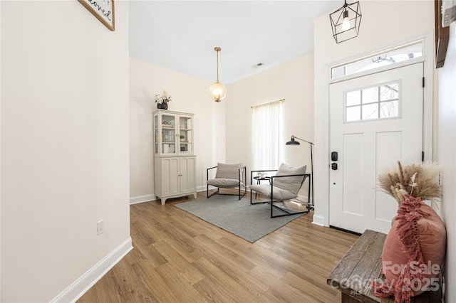 foyer entrance with baseboards and light wood-style floors