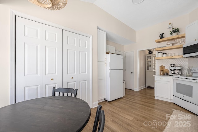 kitchen with vaulted ceiling, light wood-style floors, white cabinets, white appliances, and open shelves