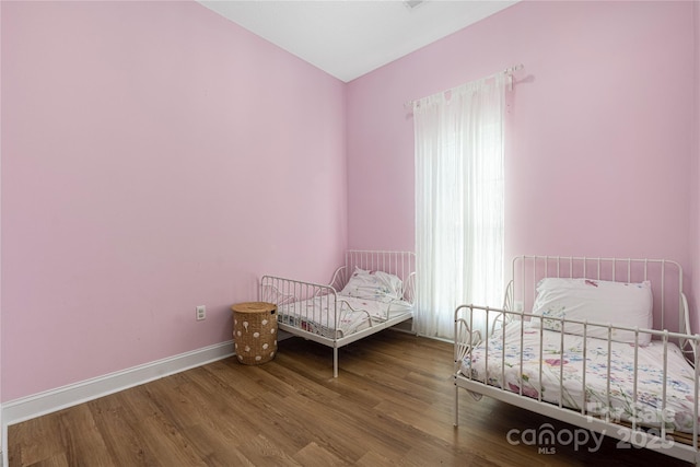 bedroom featuring wood finished floors and baseboards