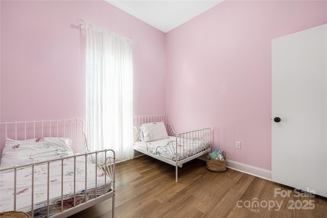 bedroom featuring baseboards and wood finished floors