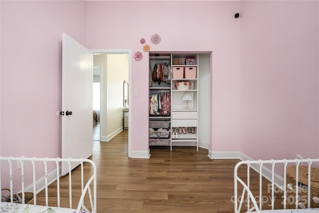 bedroom featuring baseboards and wood finished floors