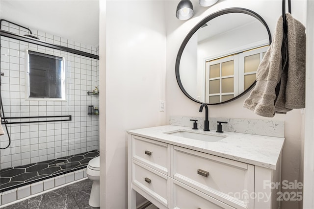 bathroom with a shower stall, toilet, and vanity