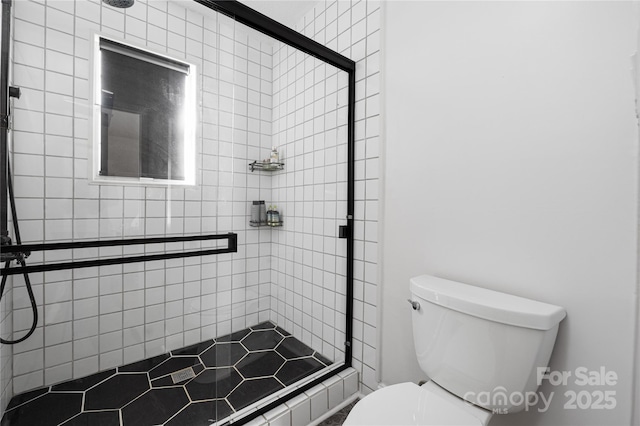 full bathroom with a shower stall and toilet