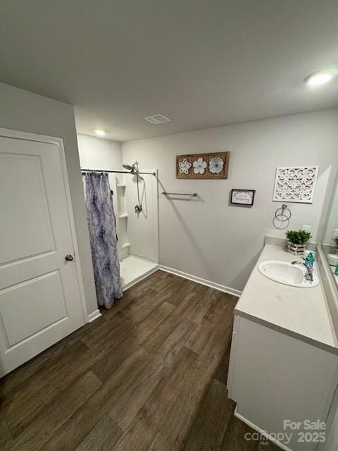 full bath with a shower with curtain, wood finished floors, and vanity