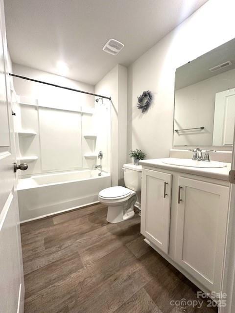 bathroom with visible vents, toilet, wood finished floors, bathing tub / shower combination, and vanity