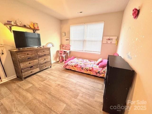 bedroom featuring wood finished floors and visible vents