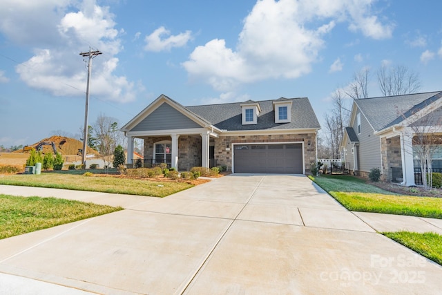 view of front of house featuring driveway, a porch, a front lawn, stone siding, and a garage