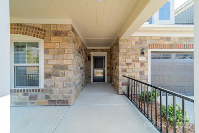 view of exterior entry featuring stone siding and an attached garage