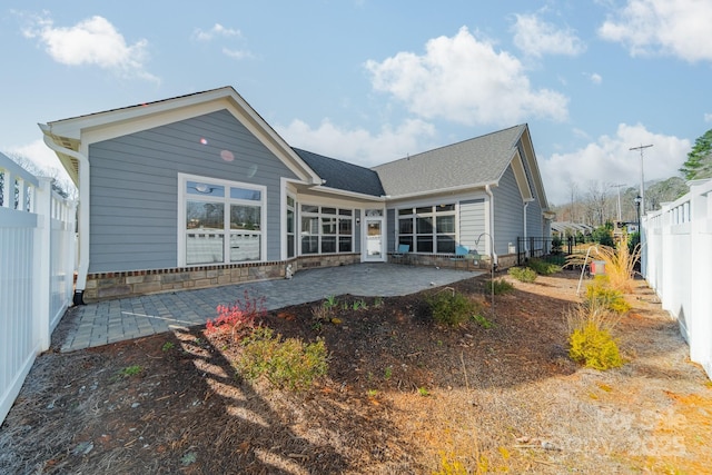 rear view of house featuring a fenced backyard and a patio area