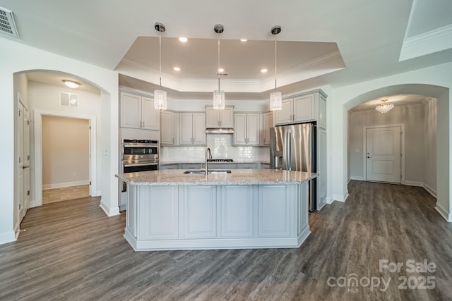 kitchen featuring tasteful backsplash, visible vents, appliances with stainless steel finishes, a raised ceiling, and a sink