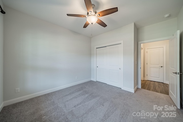 unfurnished bedroom with a closet, baseboards, carpet, and a ceiling fan