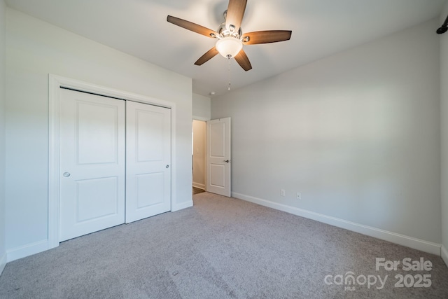 unfurnished bedroom with a closet, baseboards, a ceiling fan, and carpet flooring