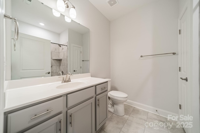 bathroom with vanity, baseboards, visible vents, tile patterned floors, and toilet