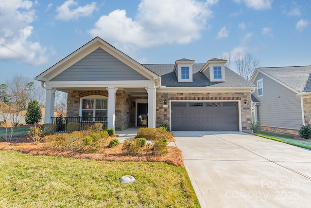 view of front of property with a front lawn, concrete driveway, roof with shingles, covered porch, and an attached garage