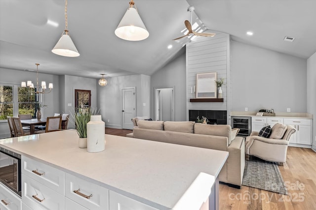 kitchen with stainless steel microwave, white cabinets, light wood-style floors, and light countertops