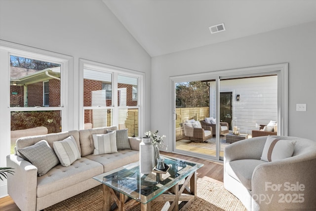 sunroom / solarium featuring visible vents and vaulted ceiling