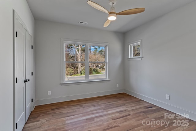 unfurnished bedroom with ceiling fan, wood finished floors, visible vents, and baseboards