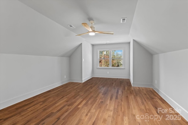 bonus room featuring visible vents, a ceiling fan, wood finished floors, baseboards, and vaulted ceiling