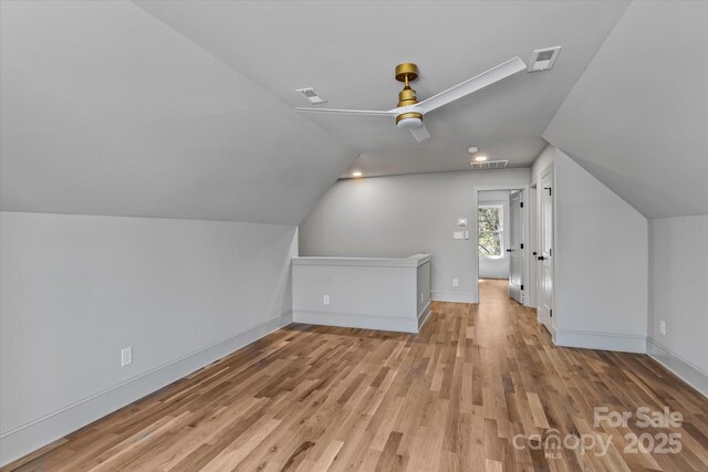 additional living space with wood finished floors, lofted ceiling, ceiling fan, and baseboards
