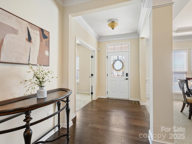 foyer with crown molding, baseboards, and wood finished floors