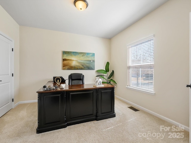 office area with baseboards, visible vents, and light carpet