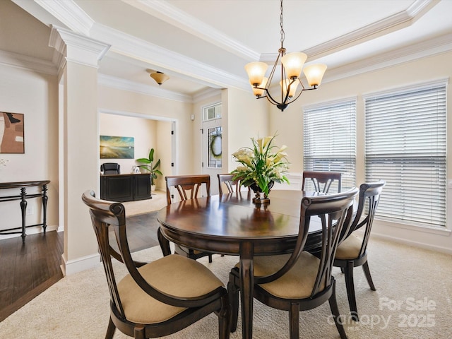 dining room with an inviting chandelier, crown molding, light colored carpet, and baseboards