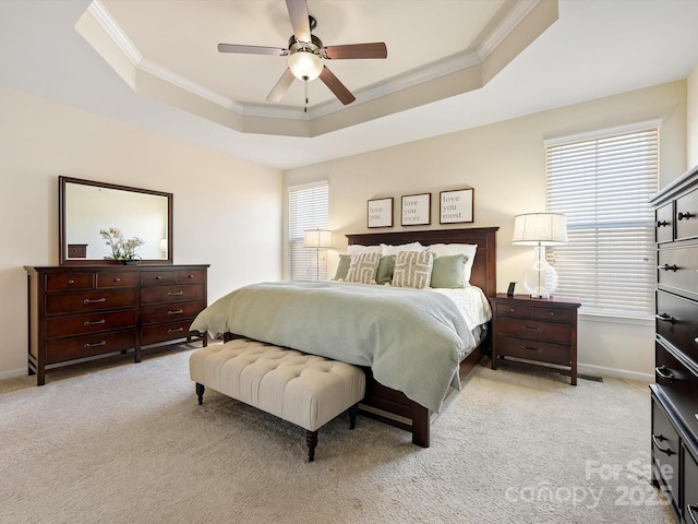 bedroom with light colored carpet, crown molding, and a tray ceiling