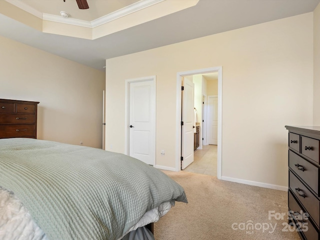 bedroom with ornamental molding, a tray ceiling, baseboards, light colored carpet, and ceiling fan